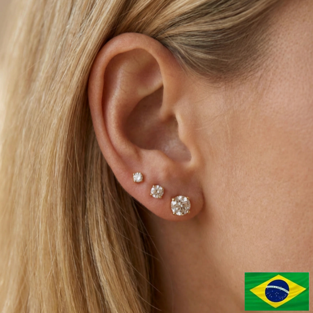 Close-up of an ear wearing diamond stud earrings with a Brazilian flag icon in the corner.