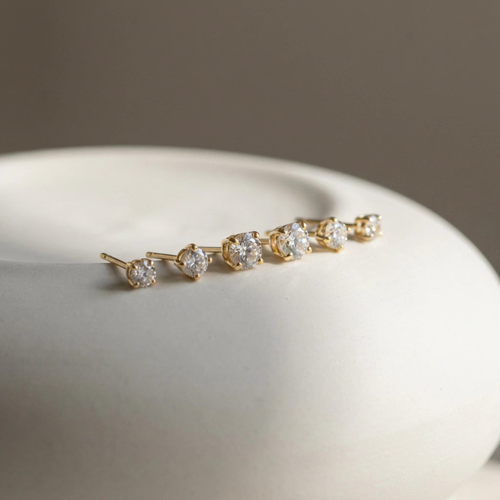 Gold earring with clear stones on a white surface