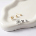 Set of floral earrings on a white stone surface
